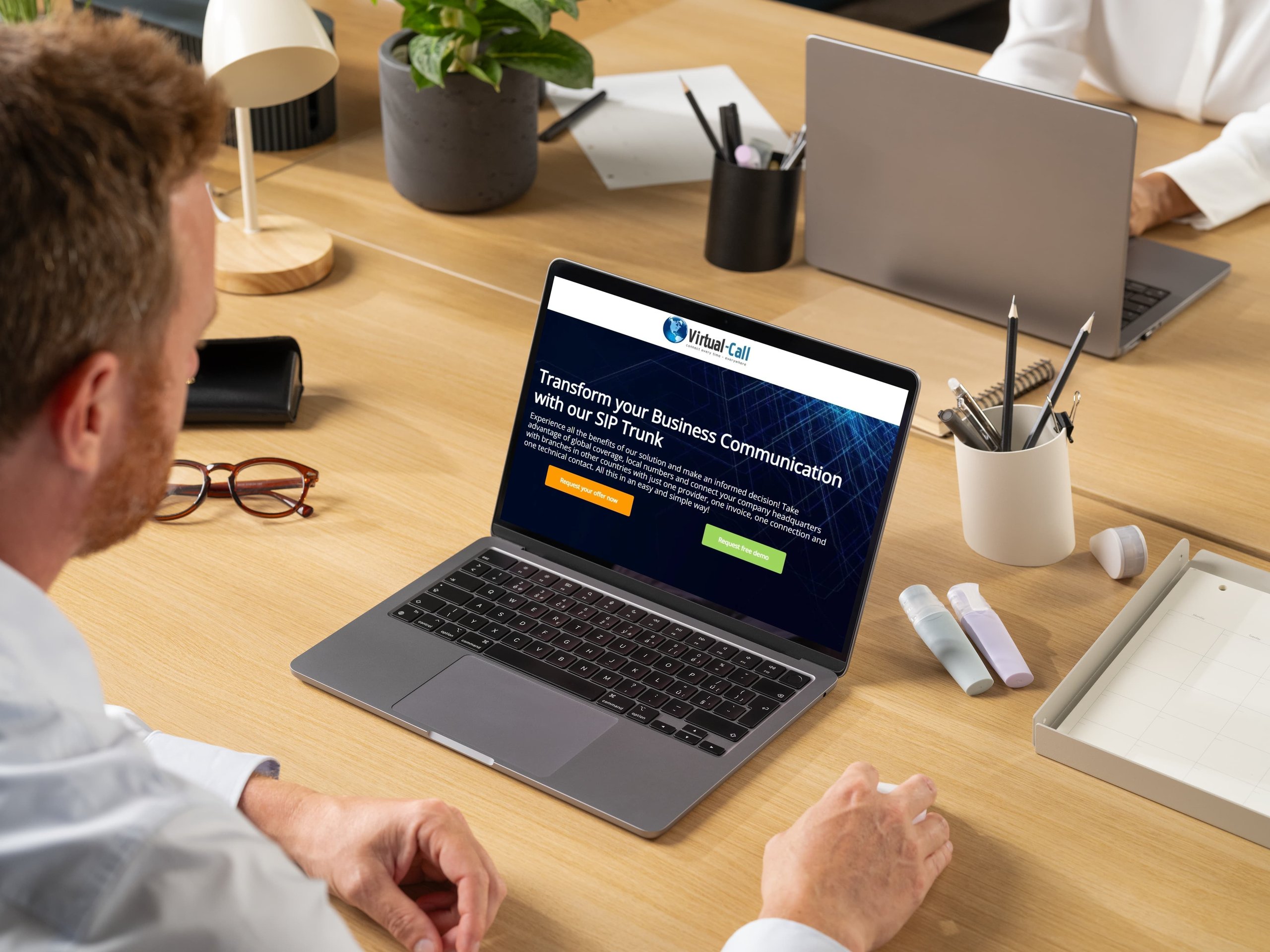 IT manager accessing Virtual-Call's 'Request free SIP Trunk trial' landing page on his laptop.