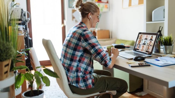 Businesswoman participating in a video conference with her team while working remotely.