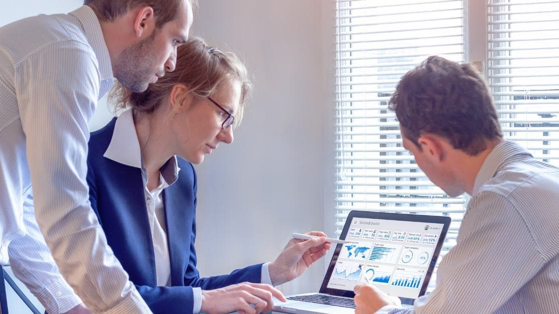 Reunião da equipe de vendas para analisar dados de chamadas de clientes e relatórios mensais para desenvolver novas estratégias.